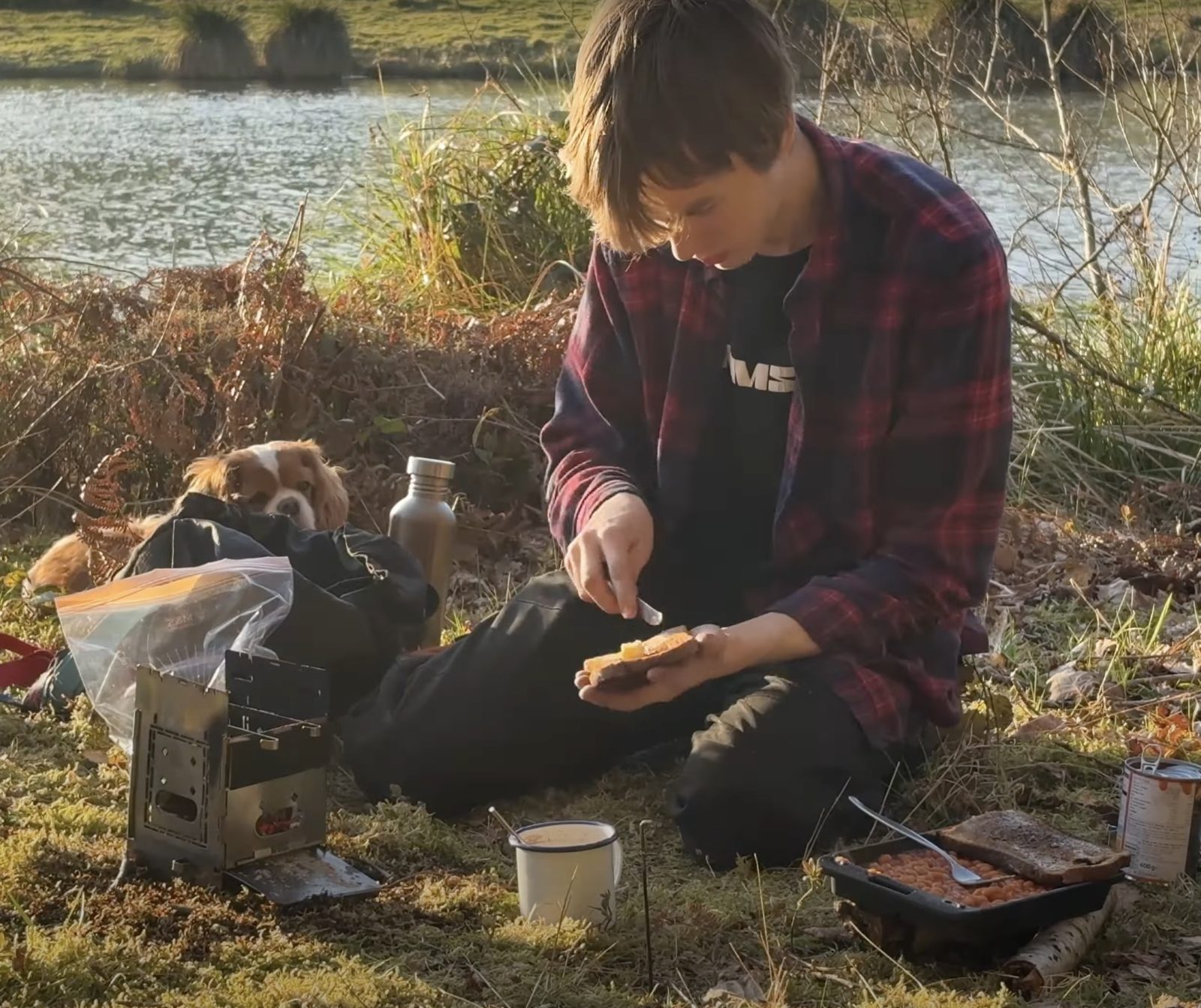 Cooking breakfast by the river on a frosty morning, with a spaniel keeping watch