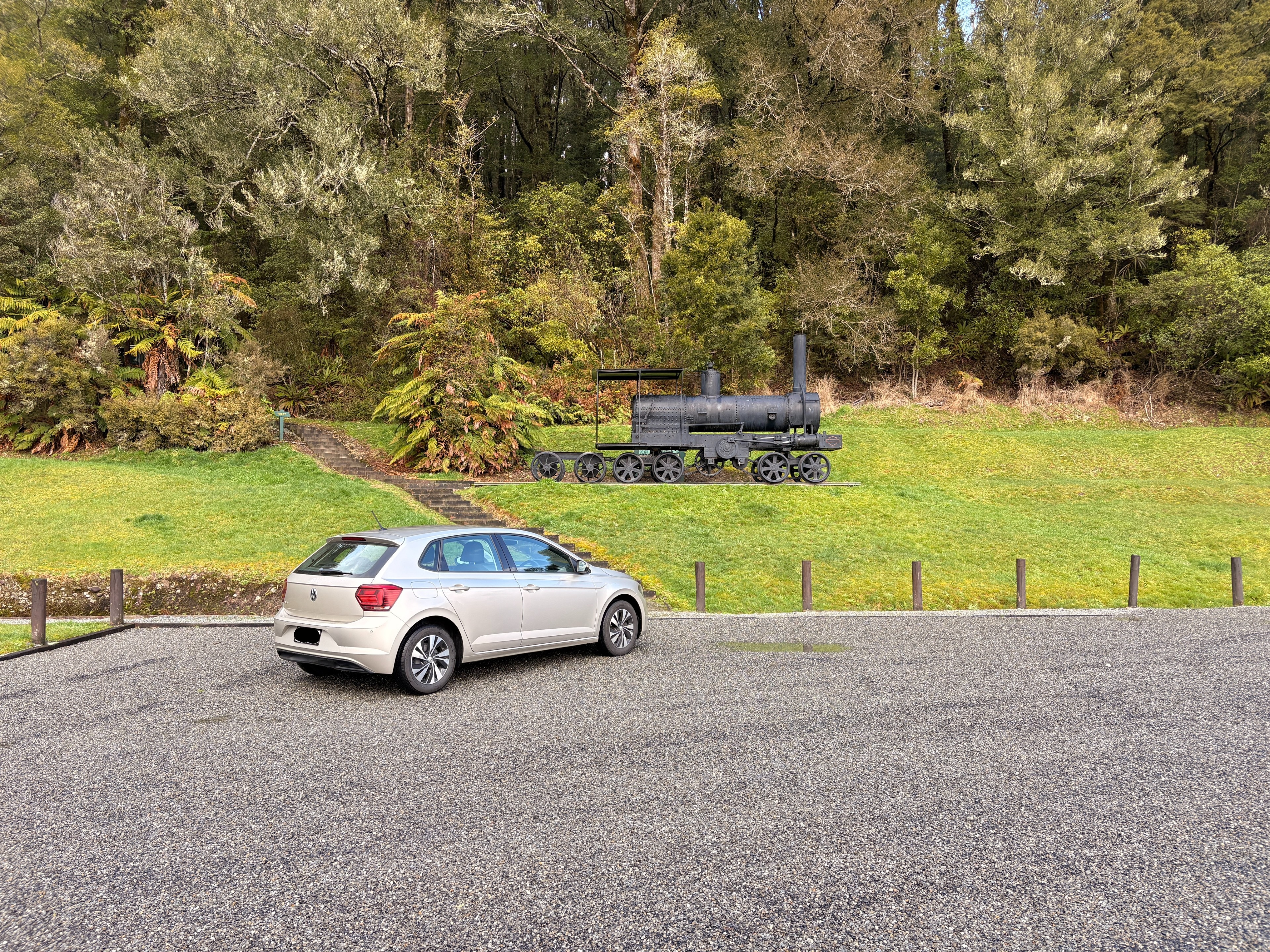 an abandoned old train on the side of the road w my car